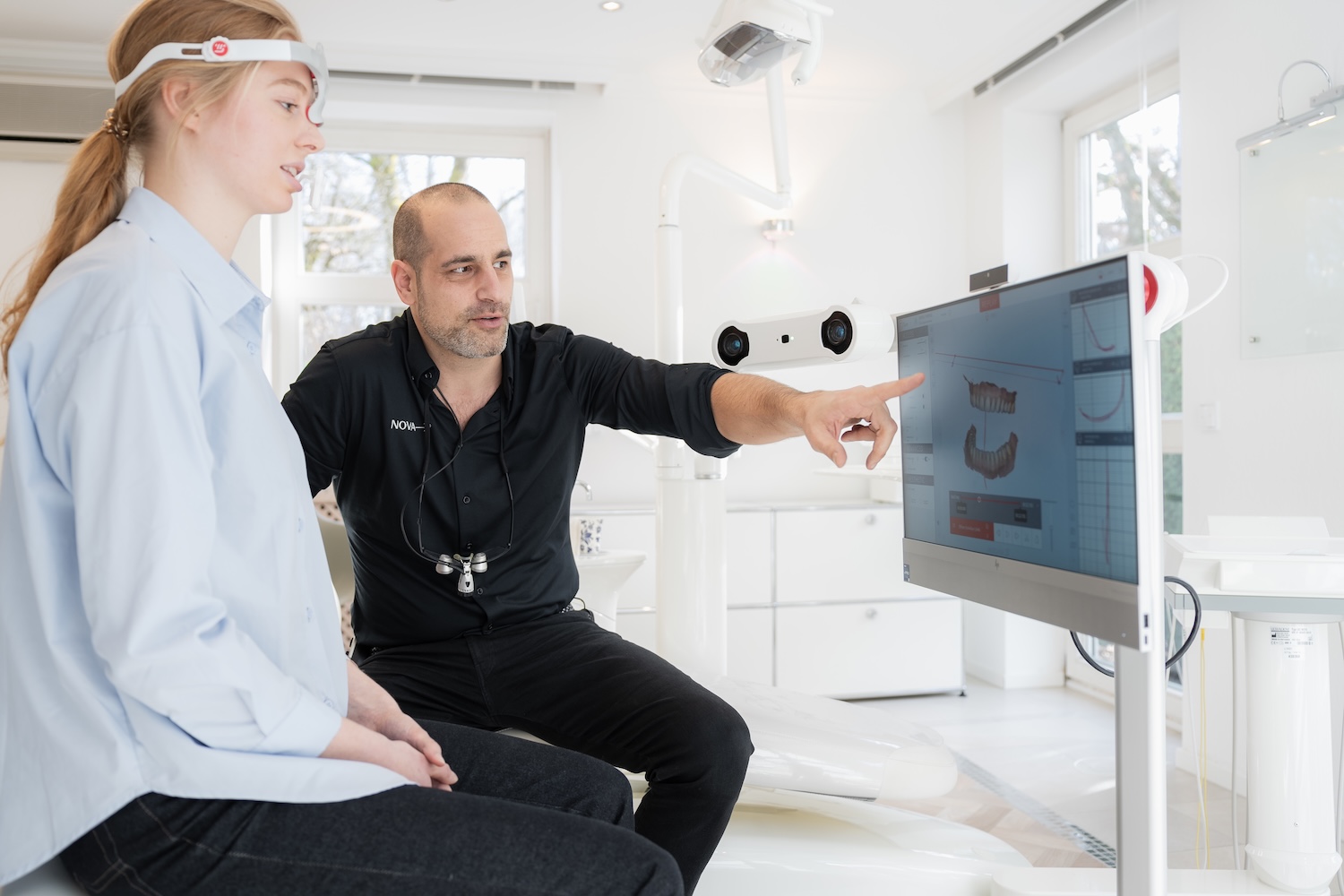 Dr. Denis Novakovic führt eine Kiefergelenksdiagnostik mit MODJAW bei einer Patientin durch