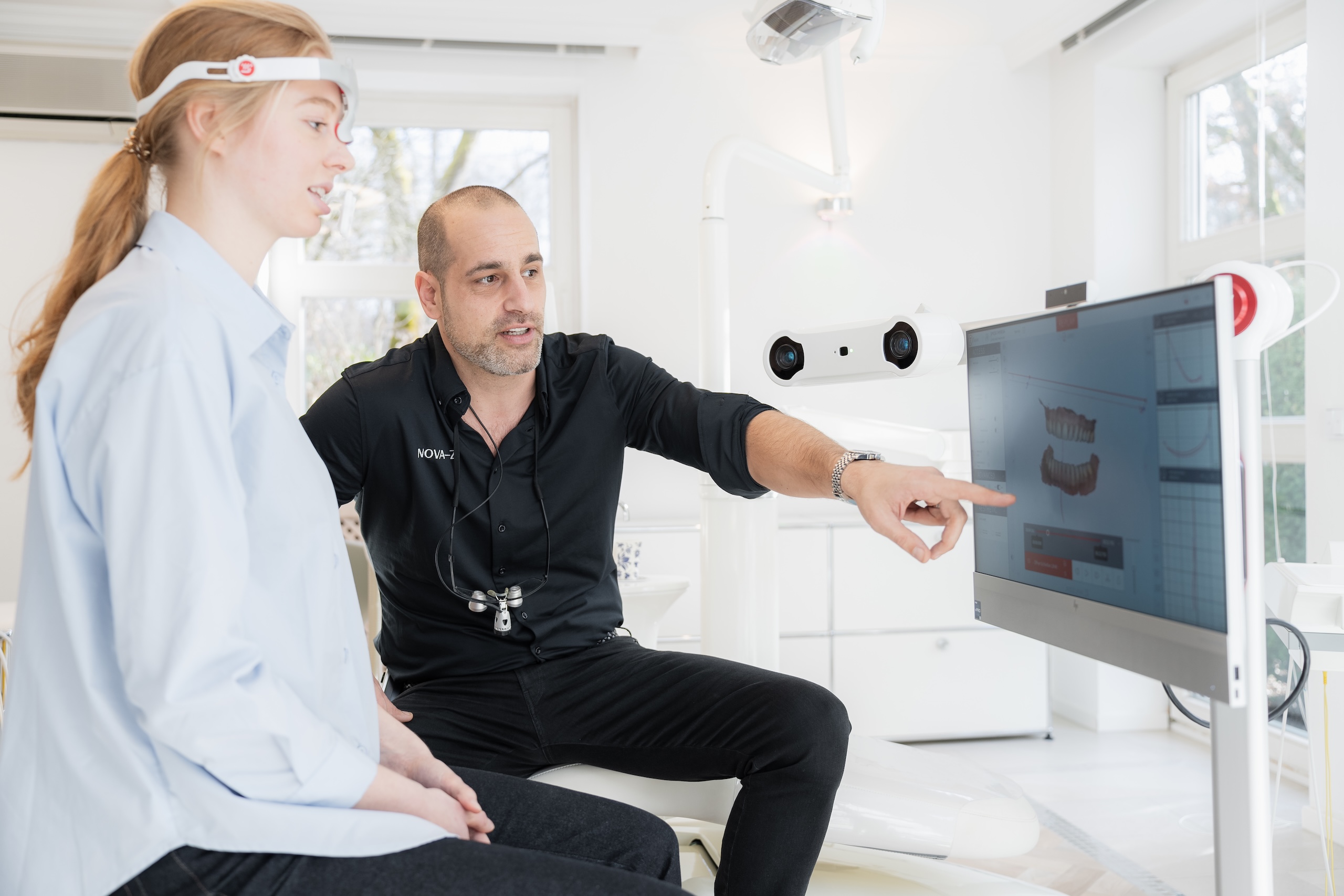Zahnarzt Dr. Novakovic führt bei einer Patientin eine MODJAW digitale Kiefervermessung zur Analyse von Kieferbewegungen und Bisslage durch